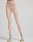 model poses in ballet-pink leggings with corset boning