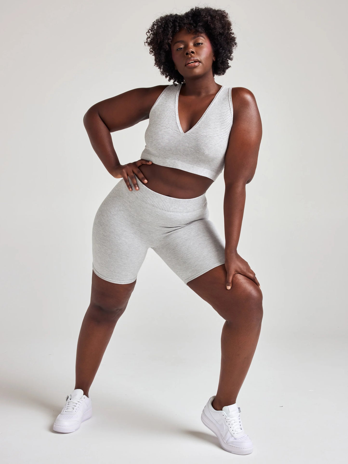 model poses in grey v-neck bralette and shorts