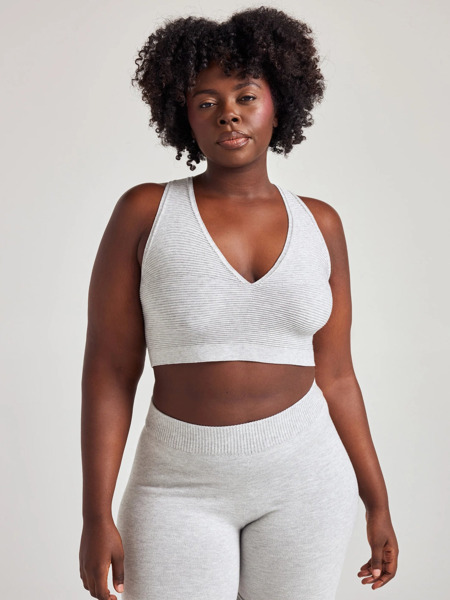 model poses in grey v-neck bralette and shorts