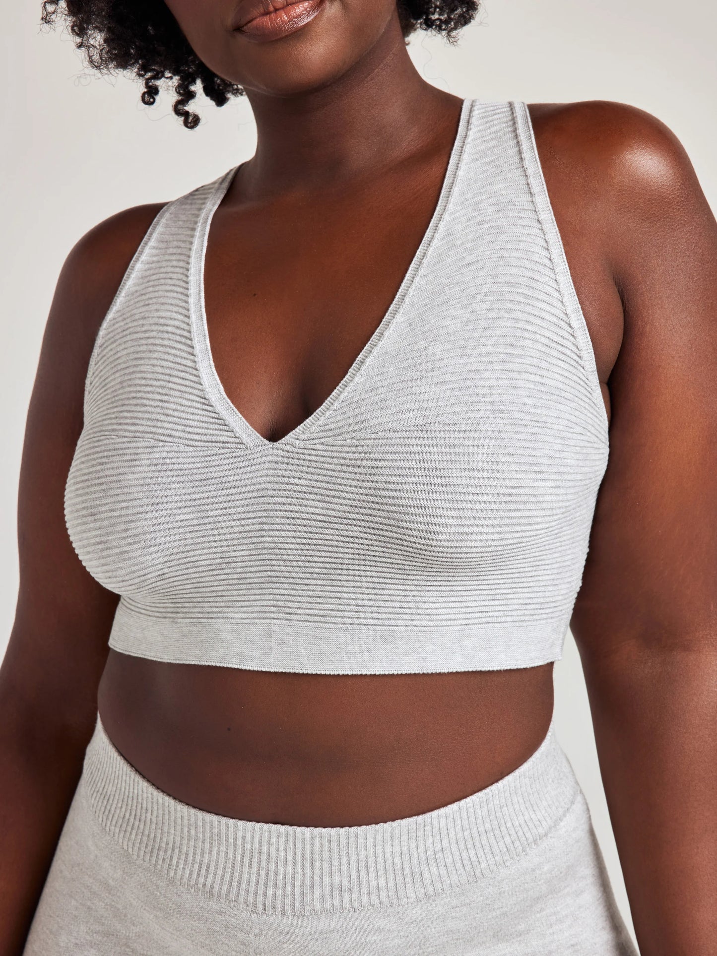 model poses in grey v-neck bralette and shorts