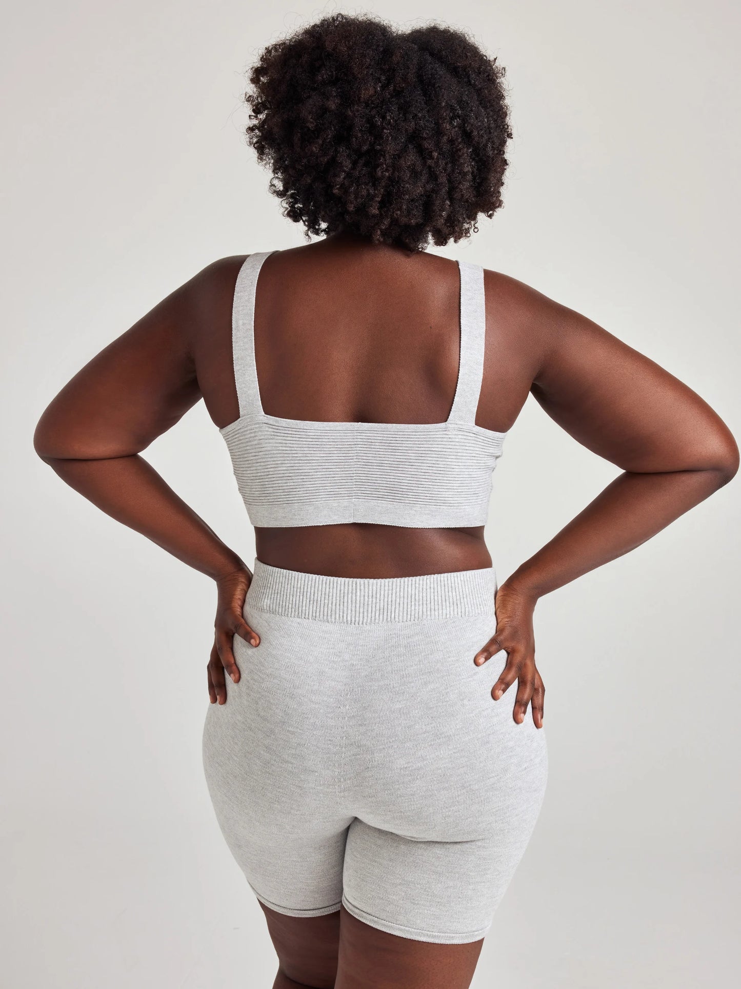 model poses in grey v-neck bralette and shorts