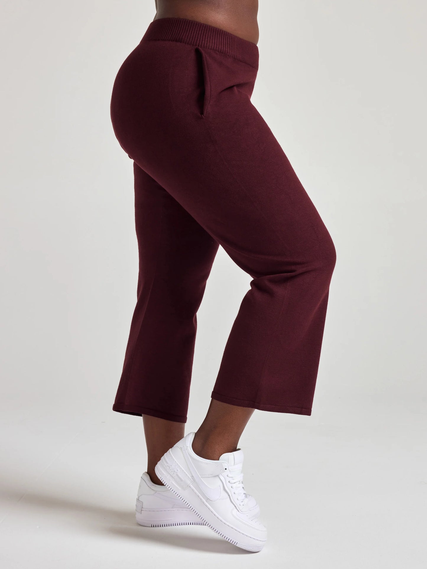 model wears sustainable cropped burgundy knit pants