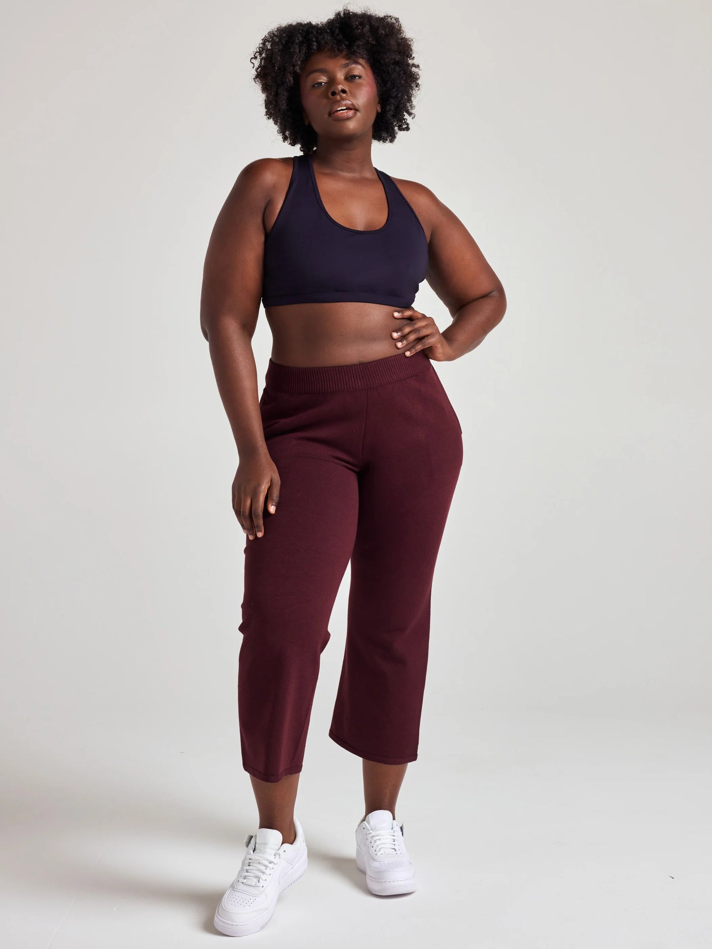 model wears sustainable cropped burgundy knit pants