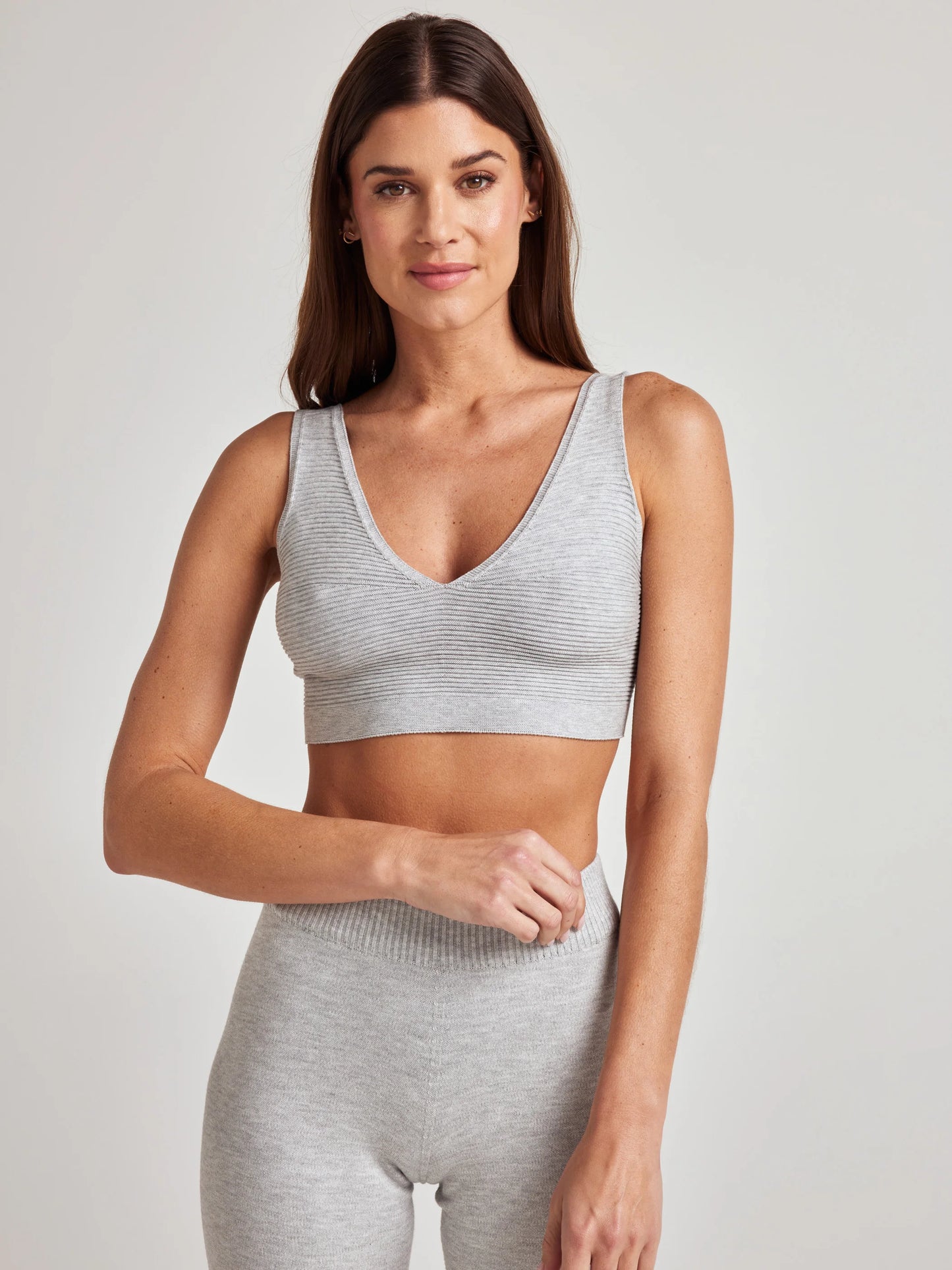 model poses in grey v-neck bralette and shorts