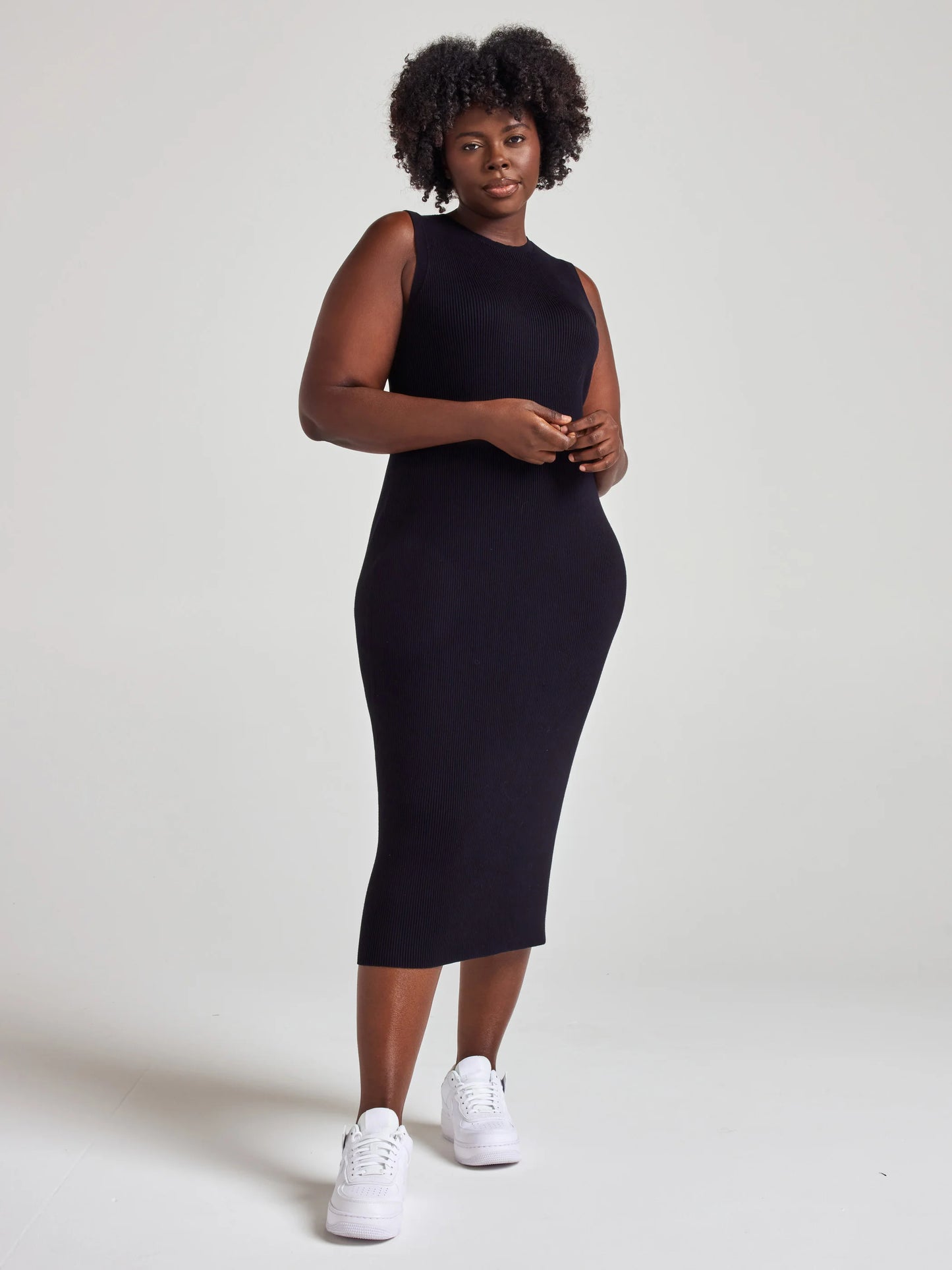 model wears sustainable black knit midi dress