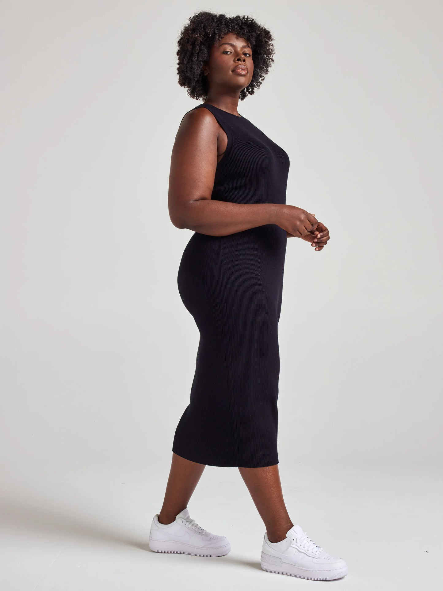 model wears sustainable black knit midi dress
