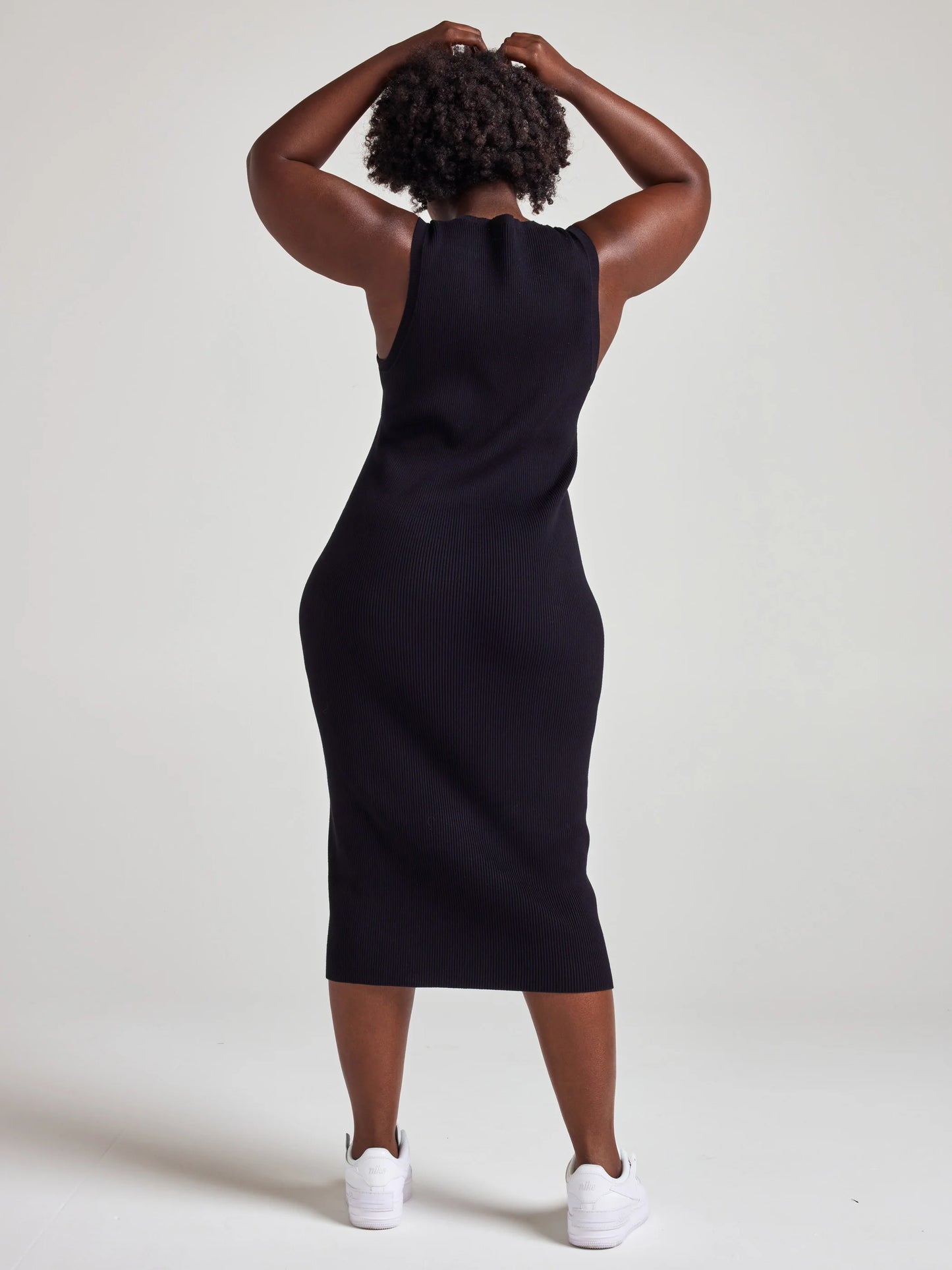model wears sustainable black knit midi dress
