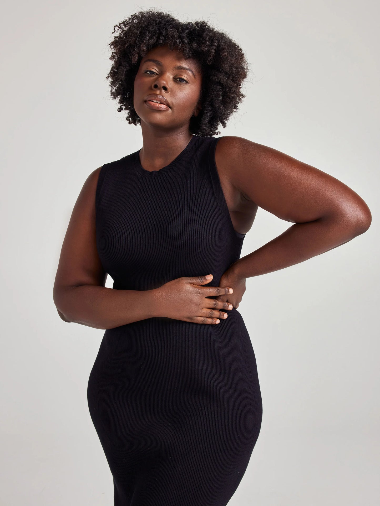 model wears sustainable black knit midi dress