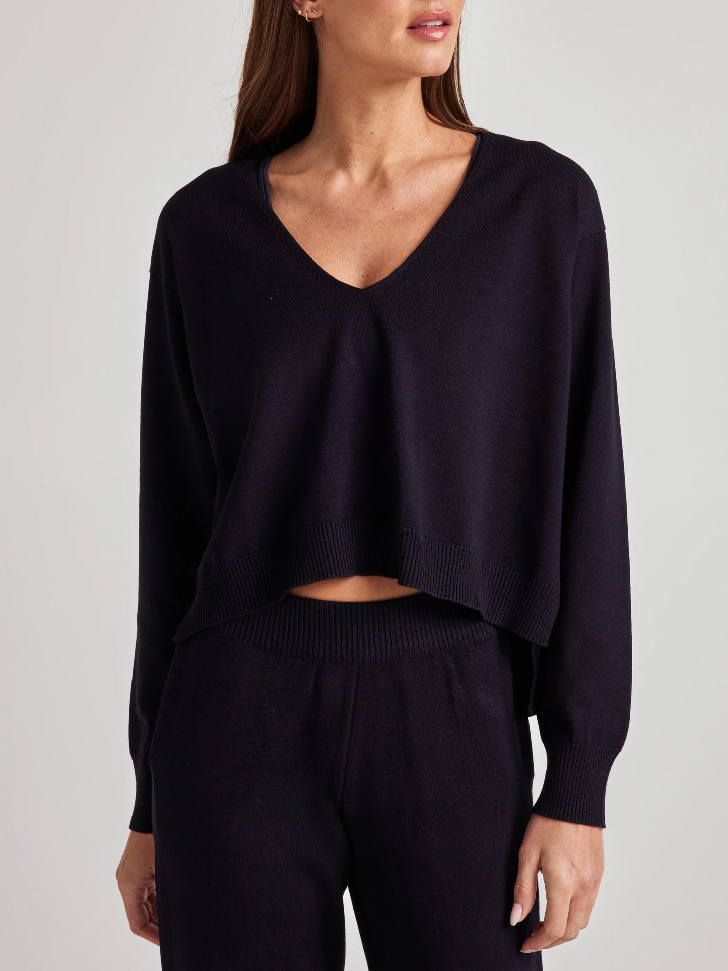 model wears sustainable cozy v neck sweater in black