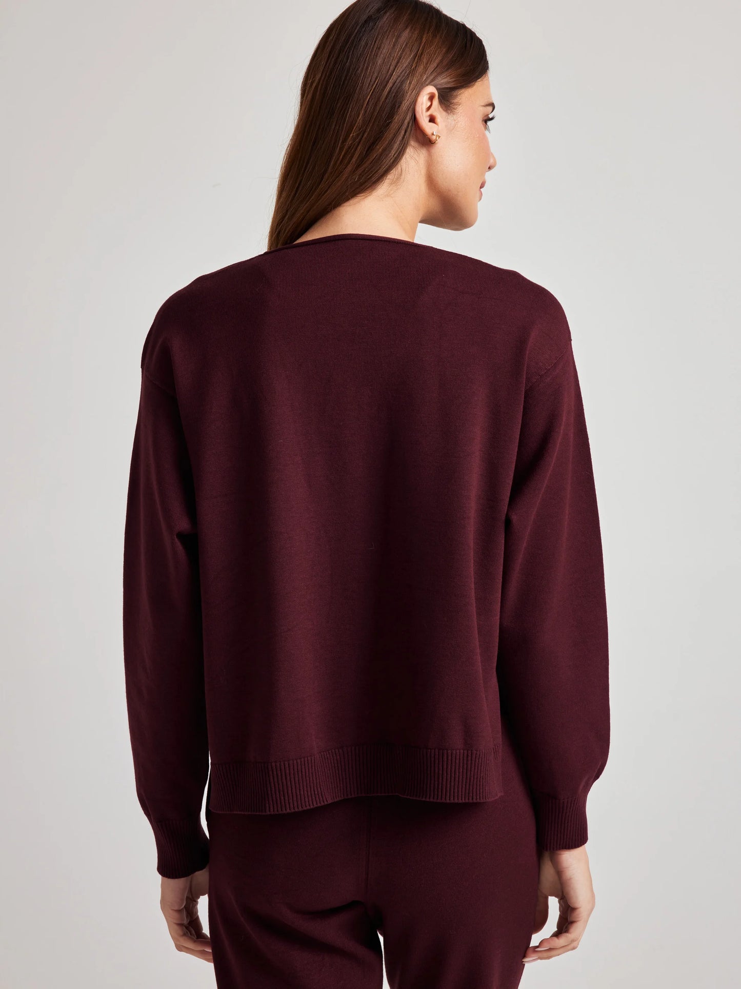 model wears sustainable cozy v neck sweater in burgundy