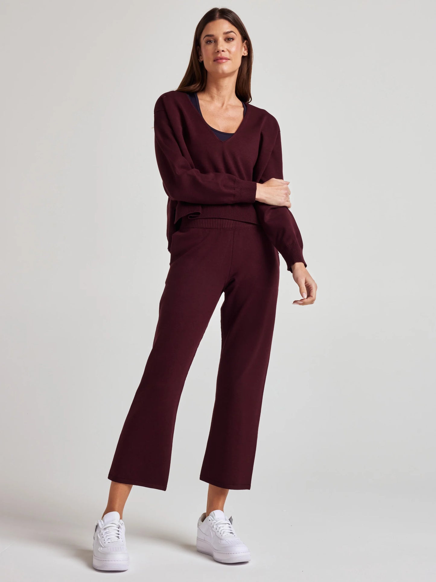model wears sustainable cozy v neck sweater in burgundy