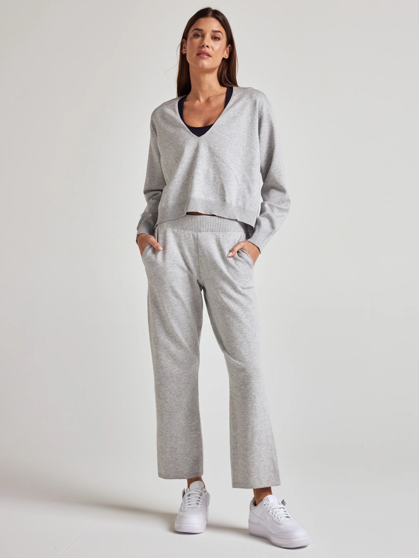 model wears sustainable cozy v neck sweater in grey