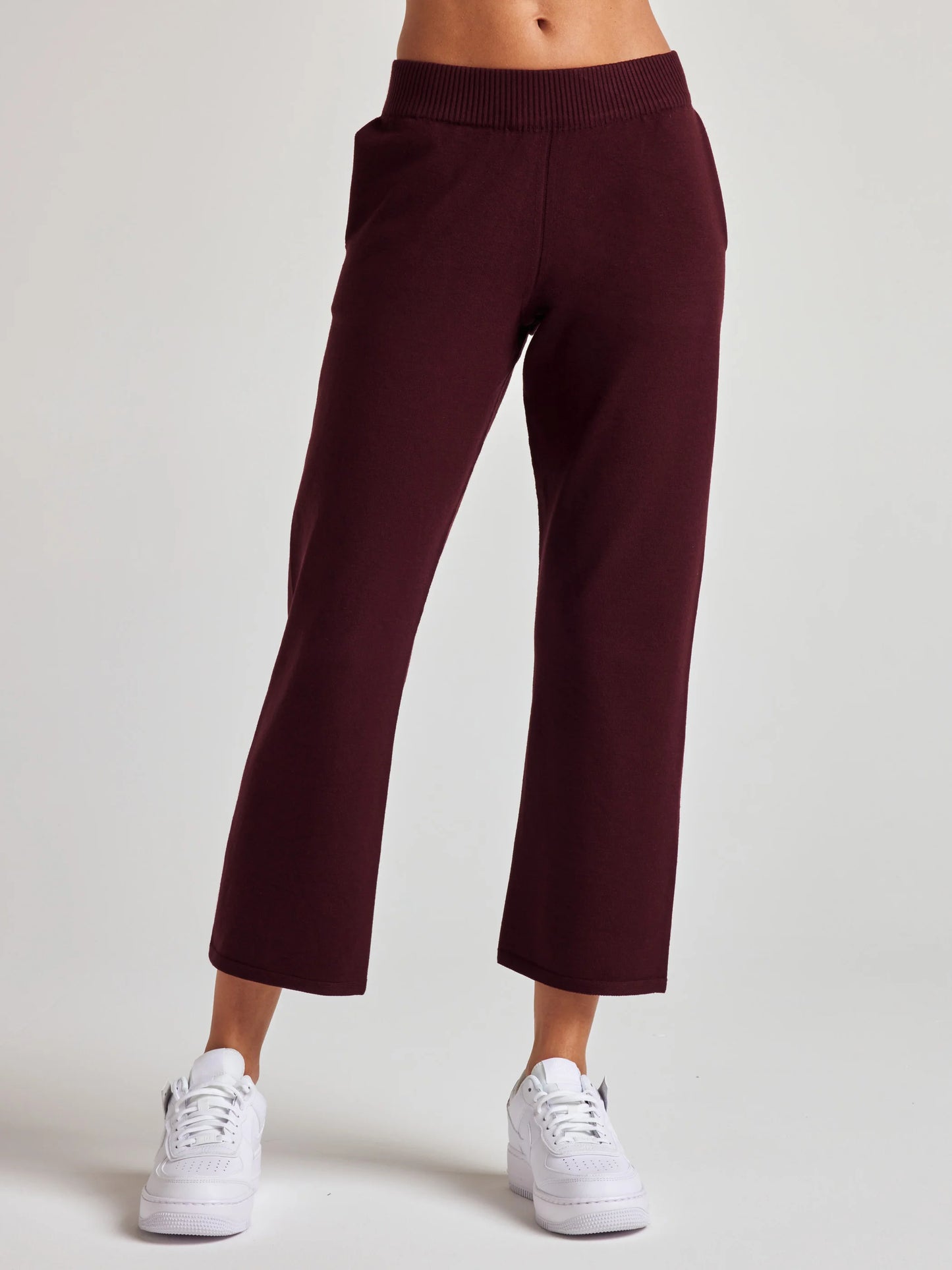 model wears sustainable cropped burgundy knit pants