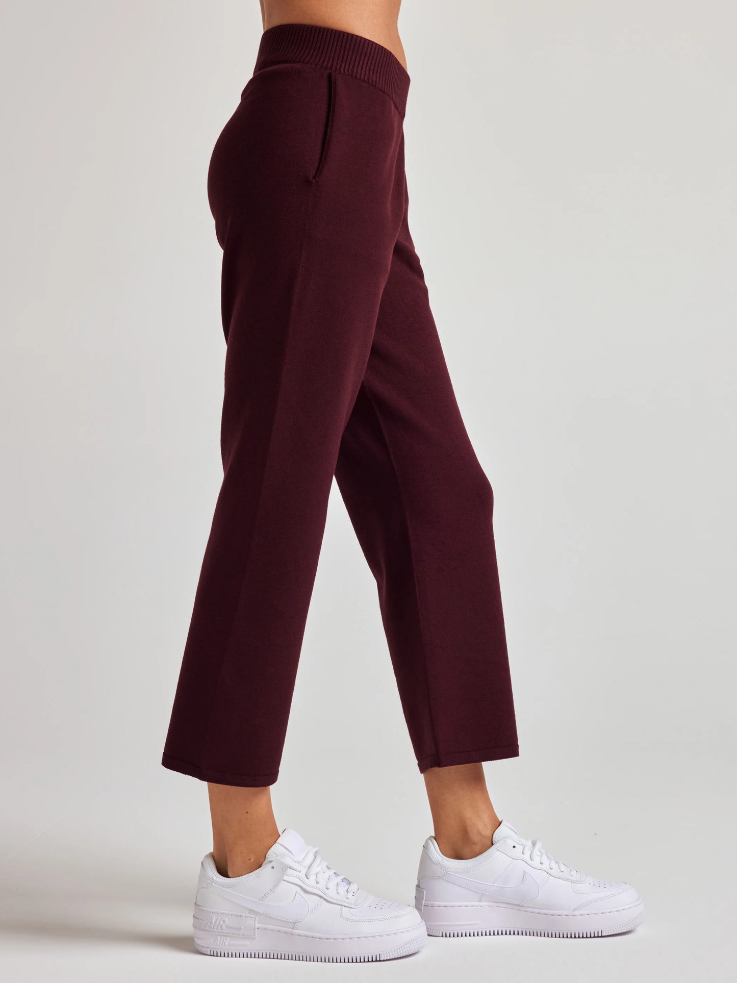 model wears sustainable cropped burgundy knit pants