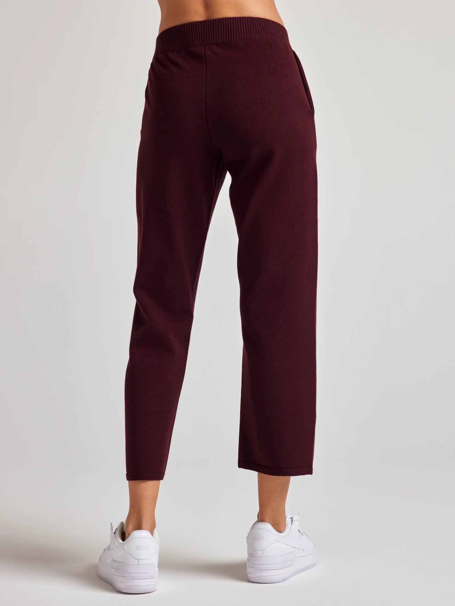model wears sustainable cropped burgundy knit pants