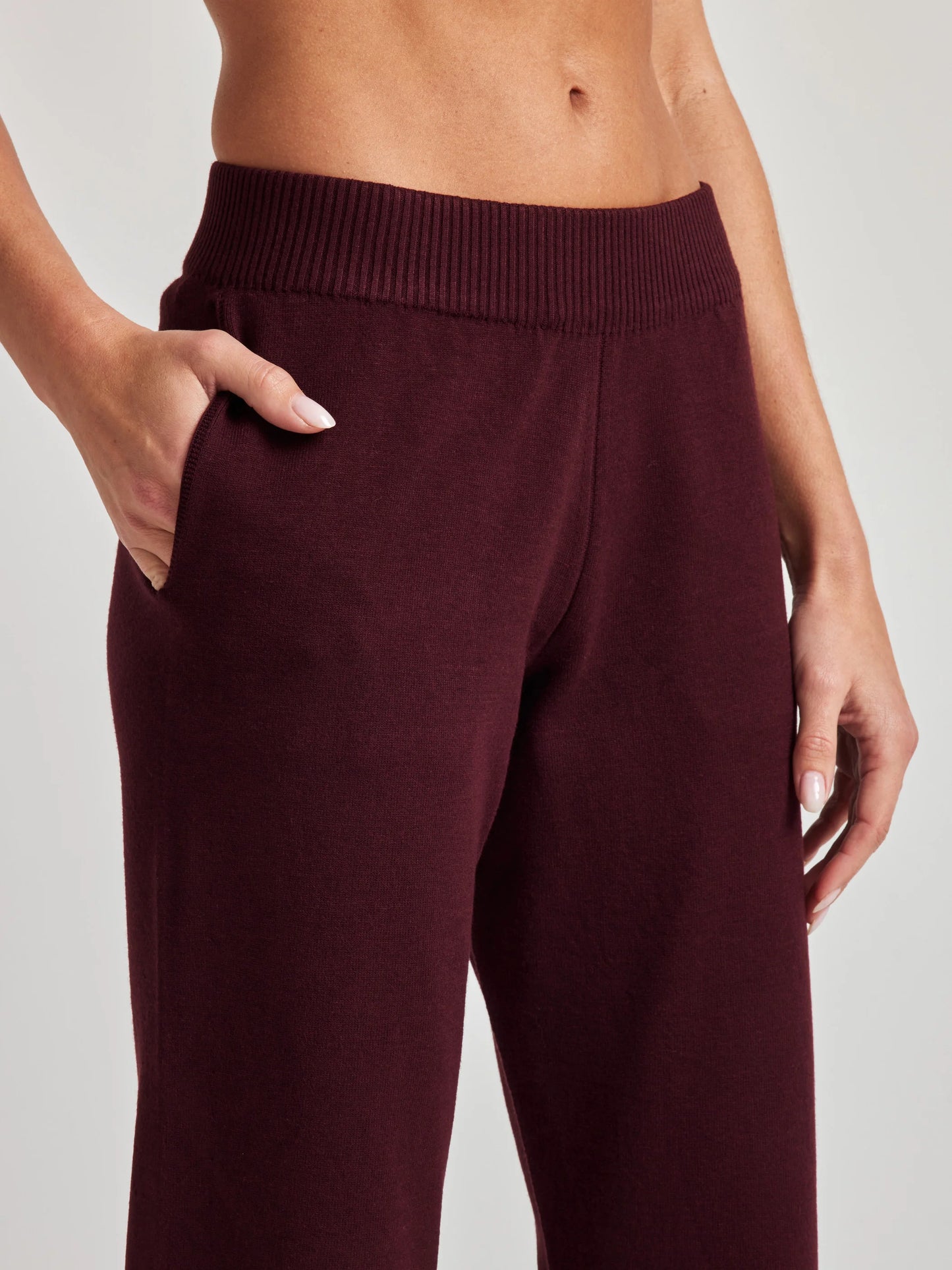 model wears sustainable cropped burgundy knit pants