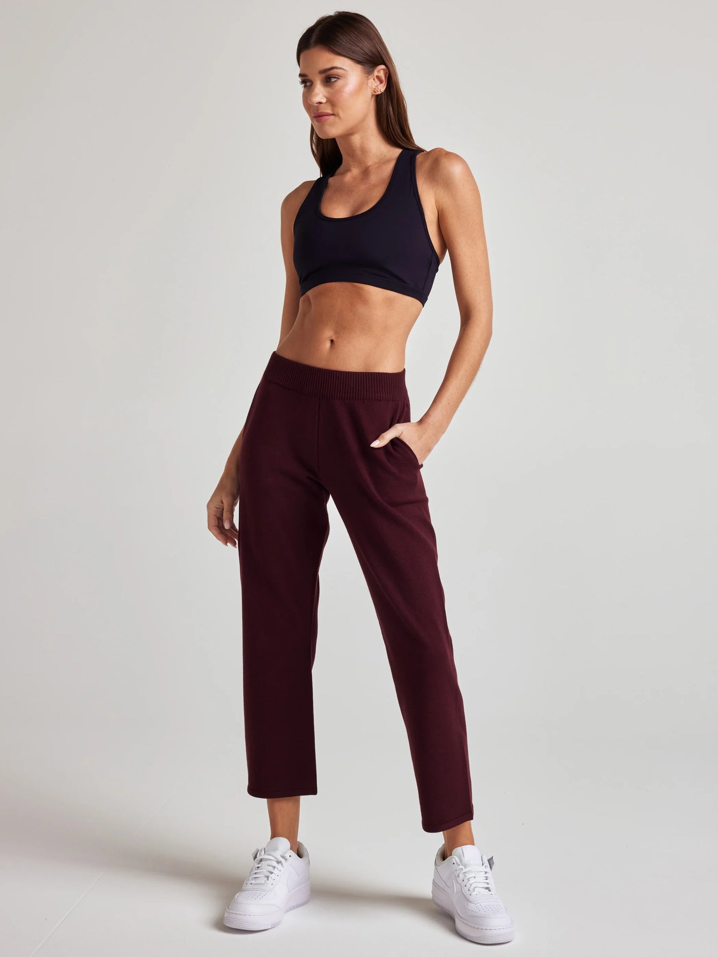 model wears sustainable cropped burgundy knit pants