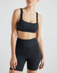 Model wears sustainable square neck black nylon rib sports bra