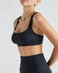 Model wears sustainable square neck black nylon rib sports bra