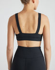 Model wears sustainable square neck black nylon rib sports bra