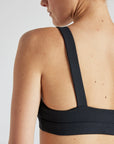 Model wears sustainable square neck black nylon rib sports bra