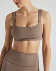 Model wears sustainable square neck light brown nylon rib sports bra