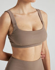 Model wears sustainable square neck light brown nylon rib sports bra