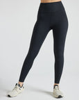 Model wears sustainable black nylon rib leggings