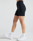 Model wears sustainable black nylon rib biker shorts