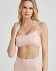 Model poses in ballet-pink bralette with corset boning