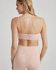 Model poses in ballet-pink bralette with corset boning