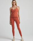 model poses in burnt orange corset tank