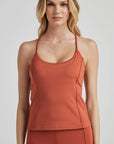 model poses in burnt orange corset tank
