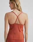 model poses in burnt orange corset tank