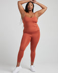 model poses in burnt orange corset tank