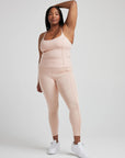 model poses in ballet-pink corset tank