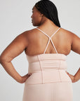 model poses in ballet-pink corset tank