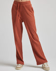 model wears relaxed waffle knit pants in baked clay