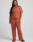 model wears relaxed waffle knit pants in baked clay