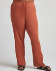 model wears relaxed waffle knit pants in baked clay