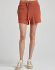model wears retro waffle knit gym shorts in baked clay