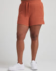 model wears retro waffle knit gym shorts in baked clay