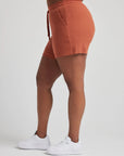 model wears retro waffle knit gym shorts in baked clay