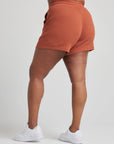 model wears retro waffle knit gym shorts in baked clay