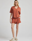 model poses in orange thermal button down with seashell buttons