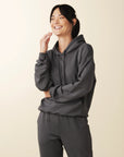 model wears cozy sustainable hoodie with pocket in grey