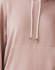 model wears cozy sustainable hoodie with pocket in blush