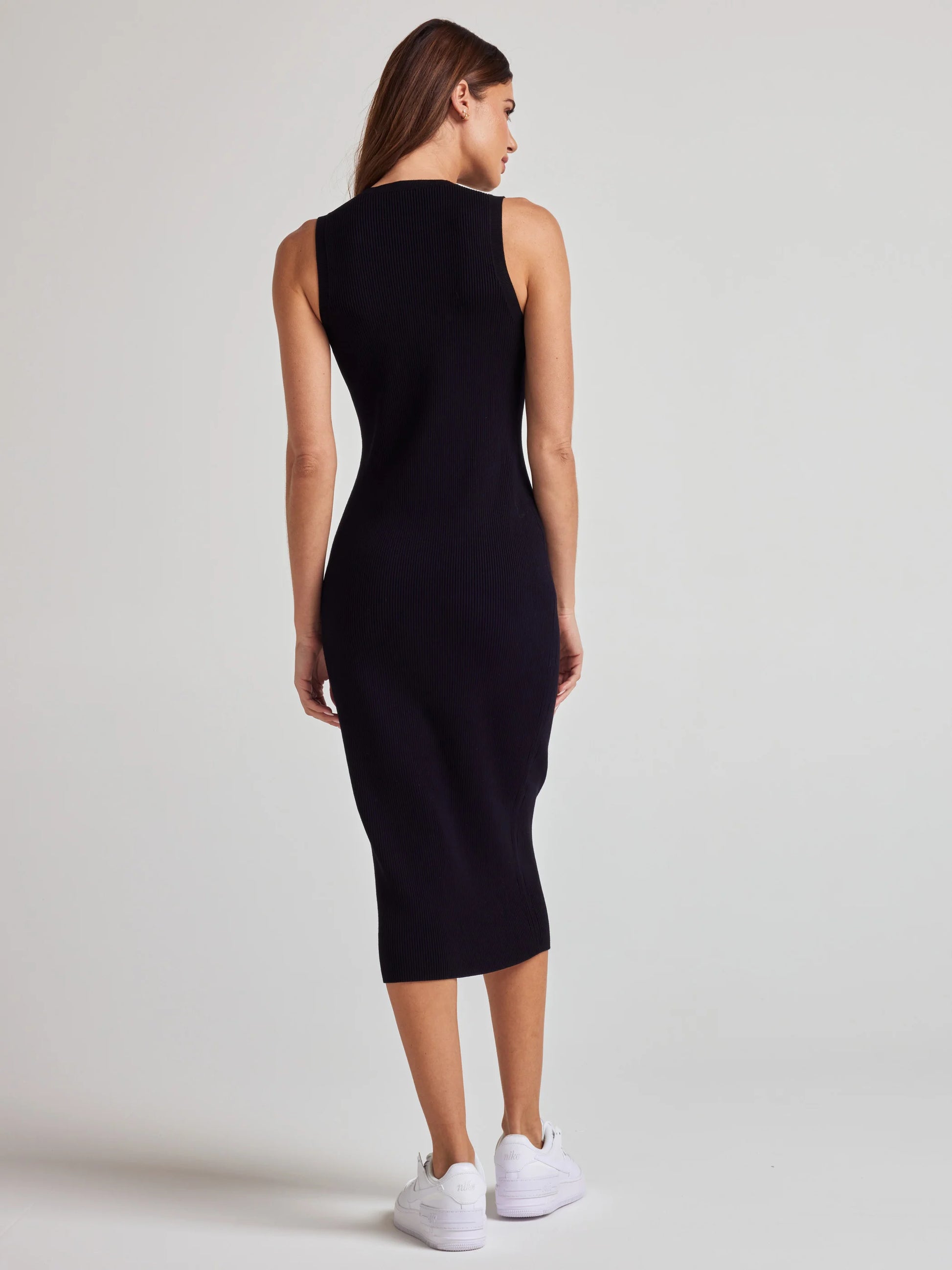 model wears sustainable black knit midi dress