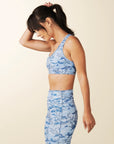 model wears blue camo sports bra with criss cross straps