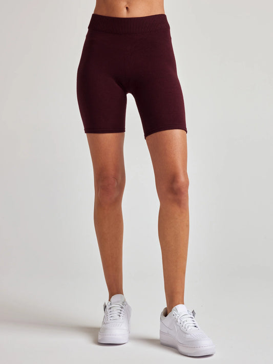 Model wears burgundy knit biker shorts with 7 1/2 inch inseam